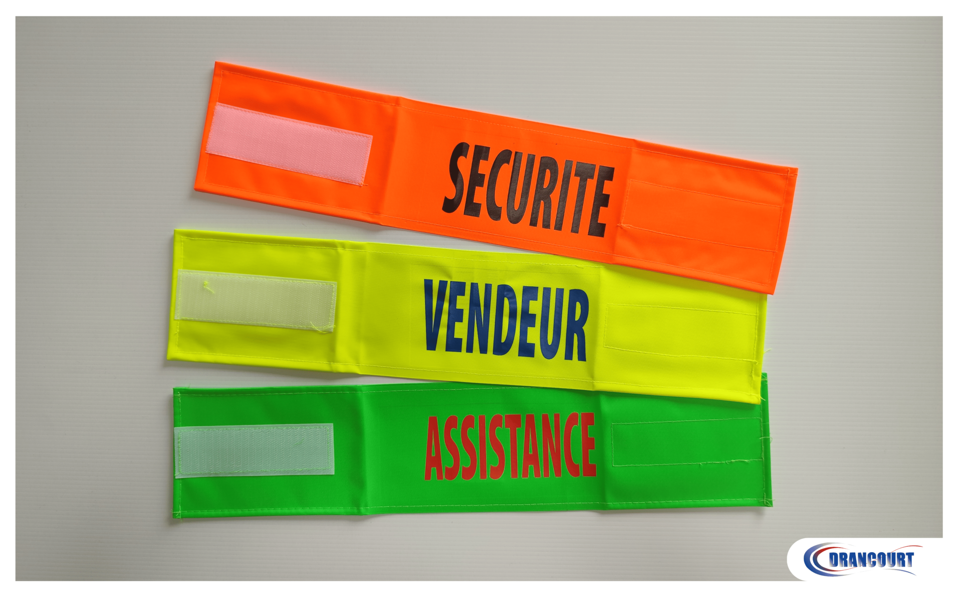 Brassards fluo avec flocage "sécurité" sur le orange, "vendeur" sur le jaune et "assistance" sur le vert